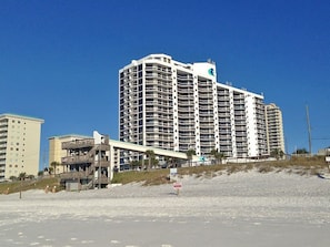 A large, multi-story hotel with a prominent 'SunSide' sign, located near a beach with a sandy foreground and a clear blue sky. - LAST MINUTE BOOKING SAVE 20% ! OCEAN VIEWS 2 SETS OF BEACH CHAIRS & UMBRELLAS, (Miramar Beach)