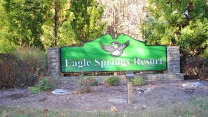 Eagle Springs -lomakeskuksen kyltti, jossa on lintukuvio ja taustalla kivimuuri.