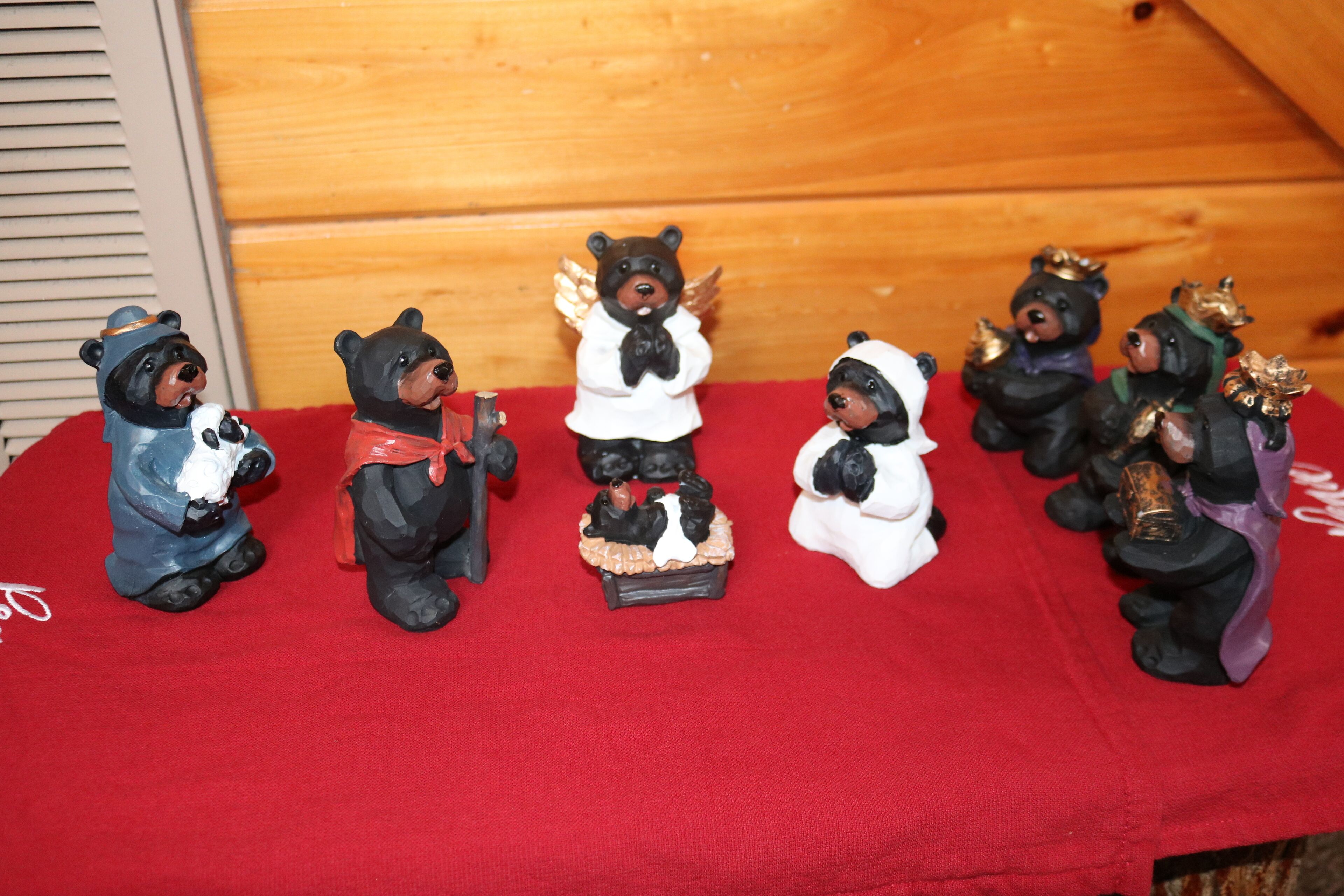A collection of bear figurines on a red cloth.