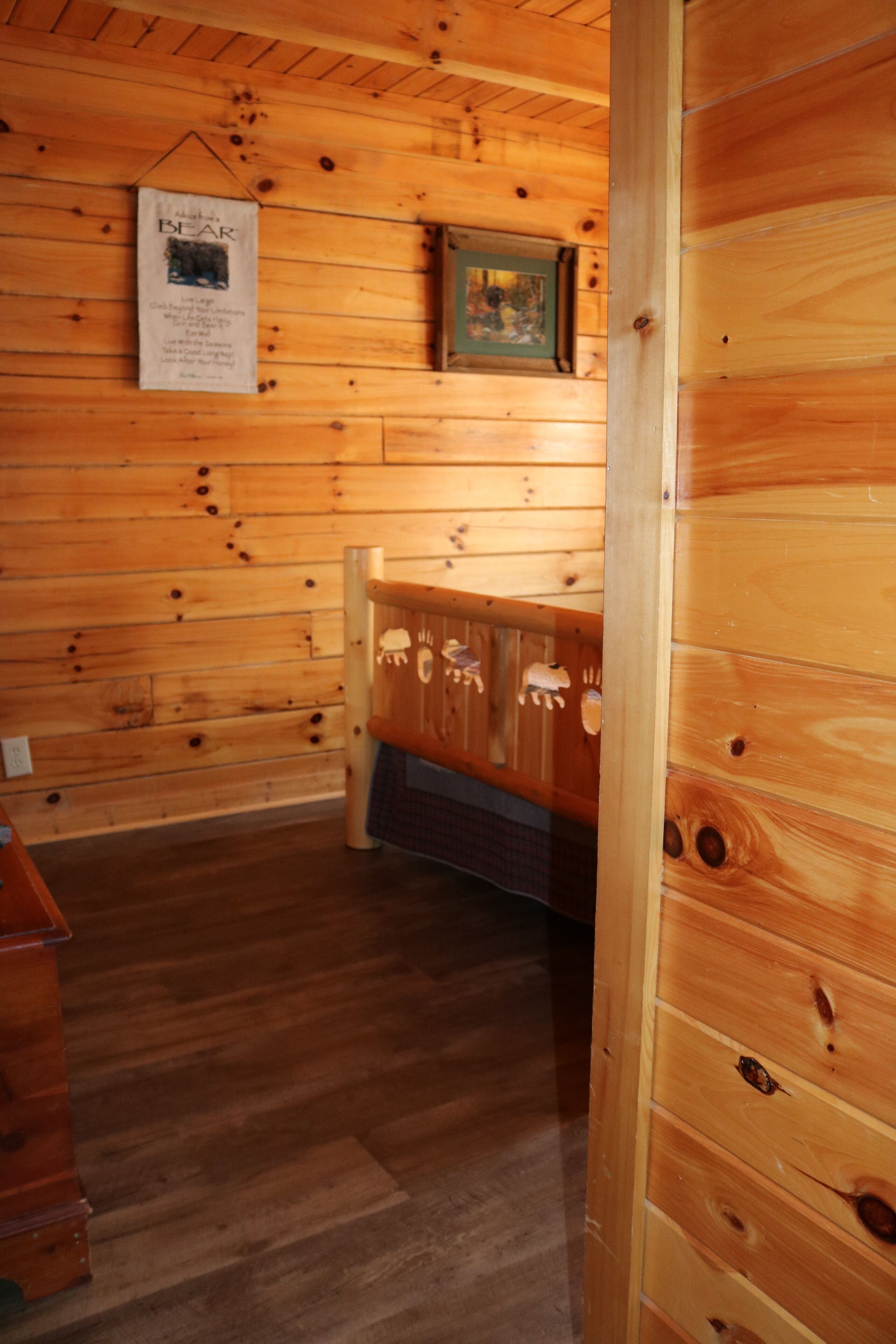 Interior de una cabaña de madera con un armario de madera y un certificado enmarcado en la pared.