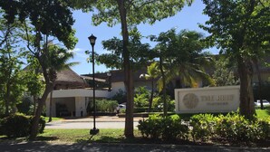 A paved pathway leading to a building with a sign reading "The Reef Playa Resort". - Spacious, quiet and safe condo one block from the beach in Playacar (Playa del Carmen)