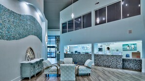A reception area with a modern design, featuring a reception desk, seating area, and a decorative wall.