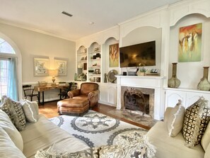 Télévision, cheminée, lecteur de DVD, livres