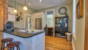 A kitchen with a central island, stainless steel appliances, and a wooden floor. - Bramley House: 3 Blk. Walk to DWTN Hendersonville-Lovingly Restored (Hendersonville)