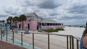 Un bâtiment rose doté d’un balcon donnant sur une plage.