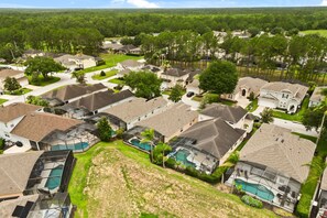A residential area with houses, a swimming pool, and a large lawn.
