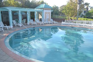 Relax by the pool surrounded by a tranquil garden and shaded seating area.