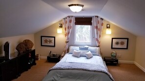 Une chambre à coucher avec un lit, des tables de chevet, une commode et des tableaux encadrés accrochés aux murs.