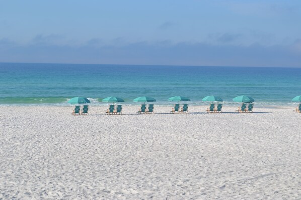 Relax on the beach with comfortable lounge chairs and umbrellas.