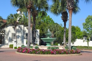 Stroll through a serene oasis surrounded by lush greenery and a tranquil fountain.