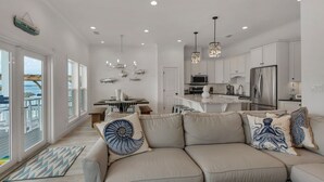 Una cocina moderna con armarios blancos, electrodomésticos de acero inoxidable y una isla central.