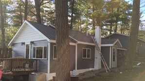 A two-story house with a deck and a ladder leaning against the house.
