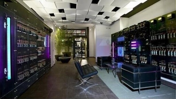 A modern interior with a central seating area, surrounded by shelves stocked with products.