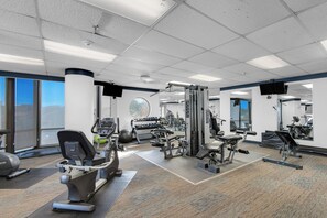A gym with cardio machines, weightlifting equipment, and mirrors.