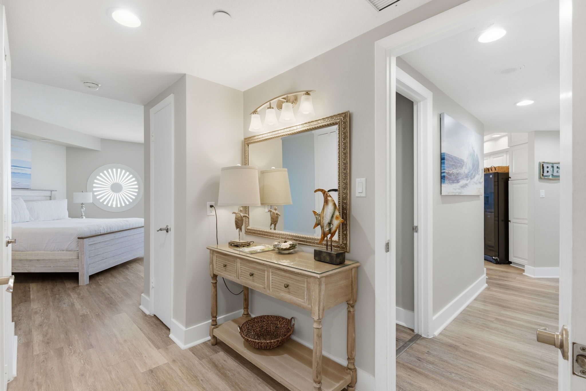 Un dormitorio con cama, mesita de noche, cómoda y un espejo grande.