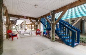 Relax in this serene outdoor space with a table and chairs, surrounded by natural surroundings and a covered roof.