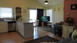 A spacious living area with a kitchen, a dining table, and a sofa.