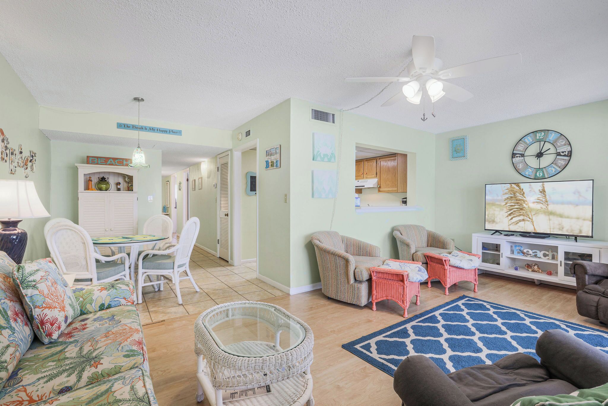 A living room with a sofa, chairs, a TV, and a dining area with a table and chairs.