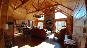 A spacious cabin interior with a kitchen, dining area, and living room.
