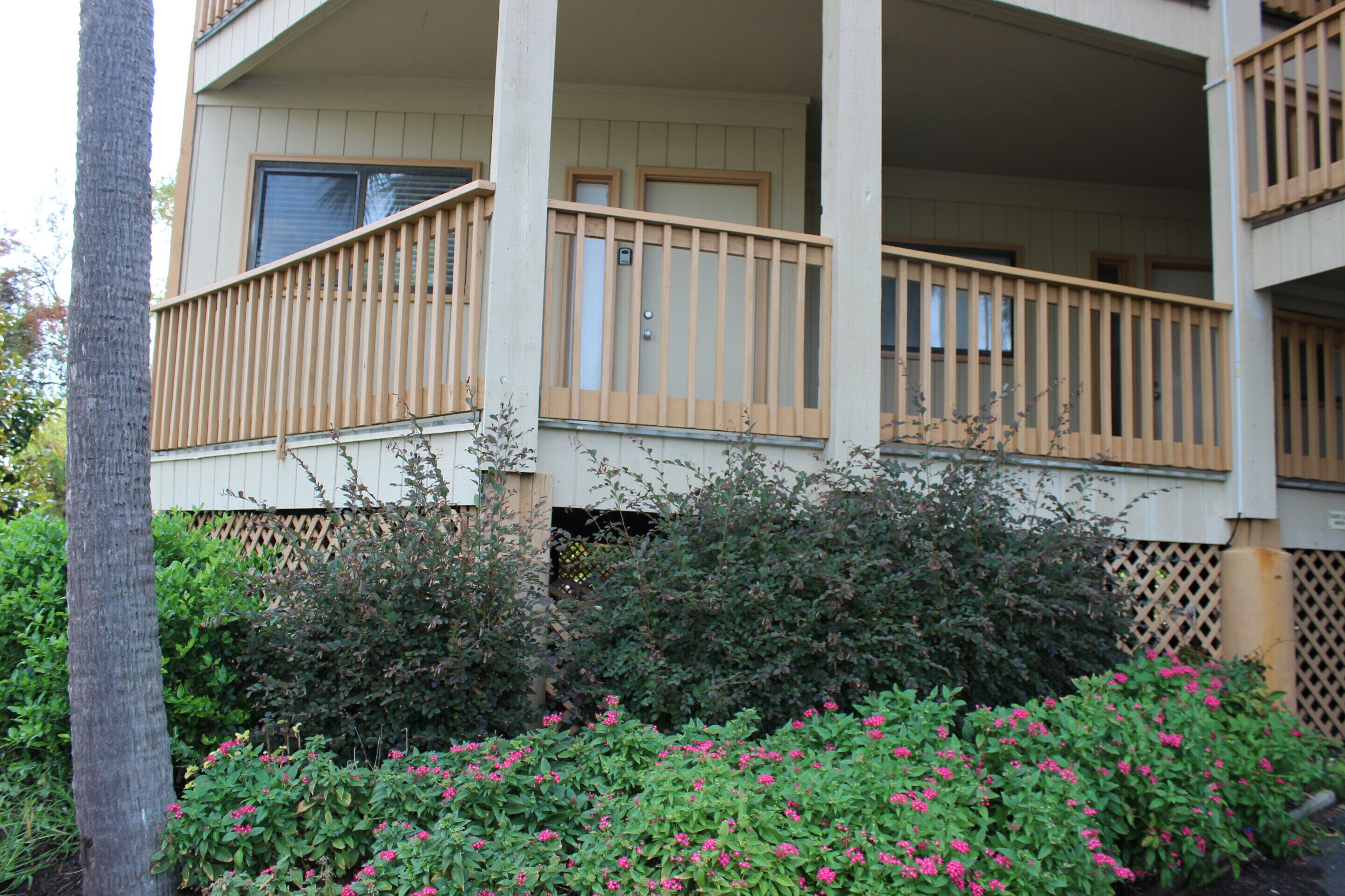 A two-story building with a balcony and a wooden fence.