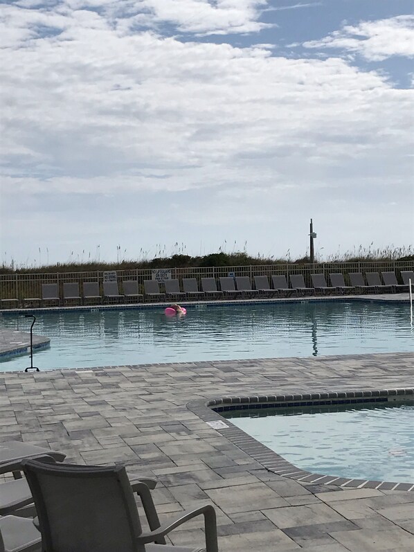 En swimmingpool med liggestole og et skilt til livredder.