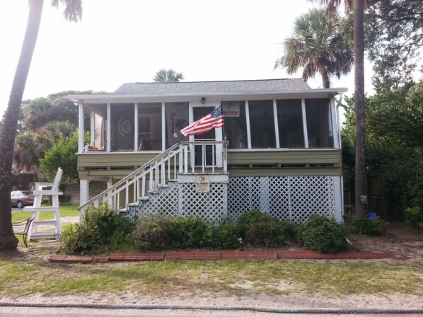 A two-story building with a covered porch, a flag, and a 'No Parking' sign.