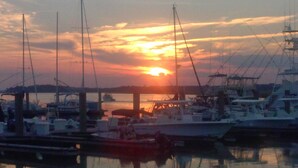 A marina with boats docked at the pier during sunset. - Beach/Pier/Restaurants/Shopping/Outstanding Location...100yards to All! Parking  (Folly Beach)