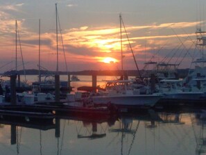 A marina with boats docked at the pier during sunset.