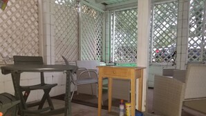 A room with a table, chairs, and a small wooden desk.