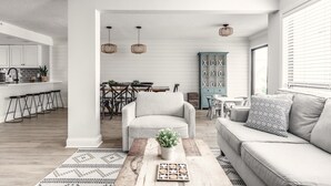 Un salon moderne comprenant un canapé, une table basse et un coin repas avec une table et des chaises.