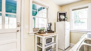 A kitchen with a built-in microwave, a coffee maker, and a refrigerator. - Fort Grounds Cottage Across from City Beach, Park & Downtown! (Coeur d'Alene)
