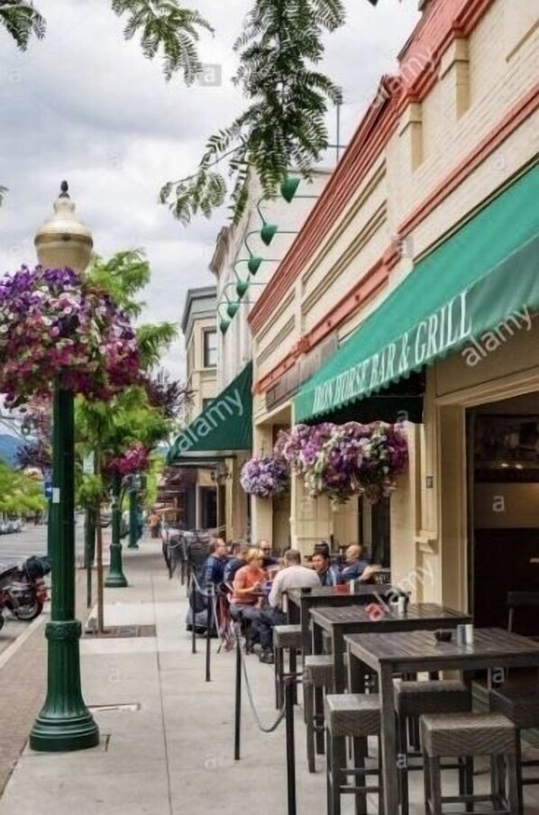 Una calle con mesas al aire libre en un restaurante llamado BRASS HORSE BAR & GRILL.