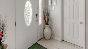 A clean, well-lit entryway with a white door, a green doormat, and a large window above the door. - Mickey's Lake Villa 2 only a few miles from Disney  (Kissimmee)