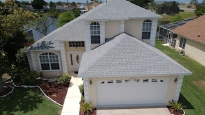 A two-story house with a garage, a driveway, and a well-maintained lawn. - Mickey's Lake Villa 2 only a few miles from Disney  (Kissimmee)