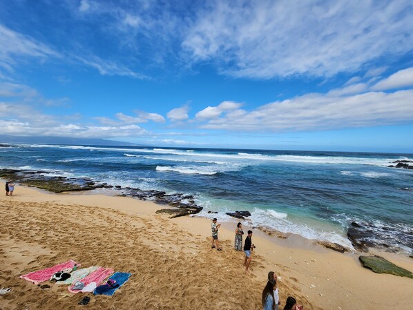 Una playa cerca, sillas reclinables de playa, toallas de playa