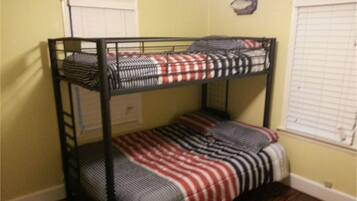 Cozy bunk bed room with a single window and striped bedding.