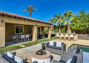 A patio area with outdoor furniture, a fire pit, and a pool.