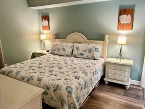 Een slaapkamer met een bed, twee nachtkastjes en twee wandlampen.