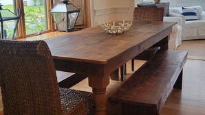 A dining area with a wooden table, woven chairs, and a bench. - July 4-11 & Jul 11-18 last-minute availability! (Rehoboth Beach)
