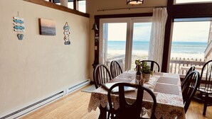 Un comedor con una mesa preparada para cuatro, con vista a la playa.