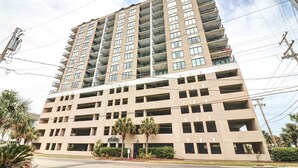 A multi-story building with a flat facade, numerous balconies, and a parking garage below. - Pristine Condo at Beachwalk Villas in North Myrtle Beach, SC Cherry Grove.  (North Myrtle Beach)