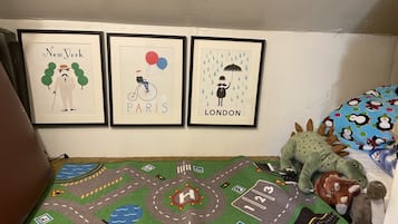 Explore a miniature city on a colorful play mat, surrounded by framed cityscapes and plush toys.