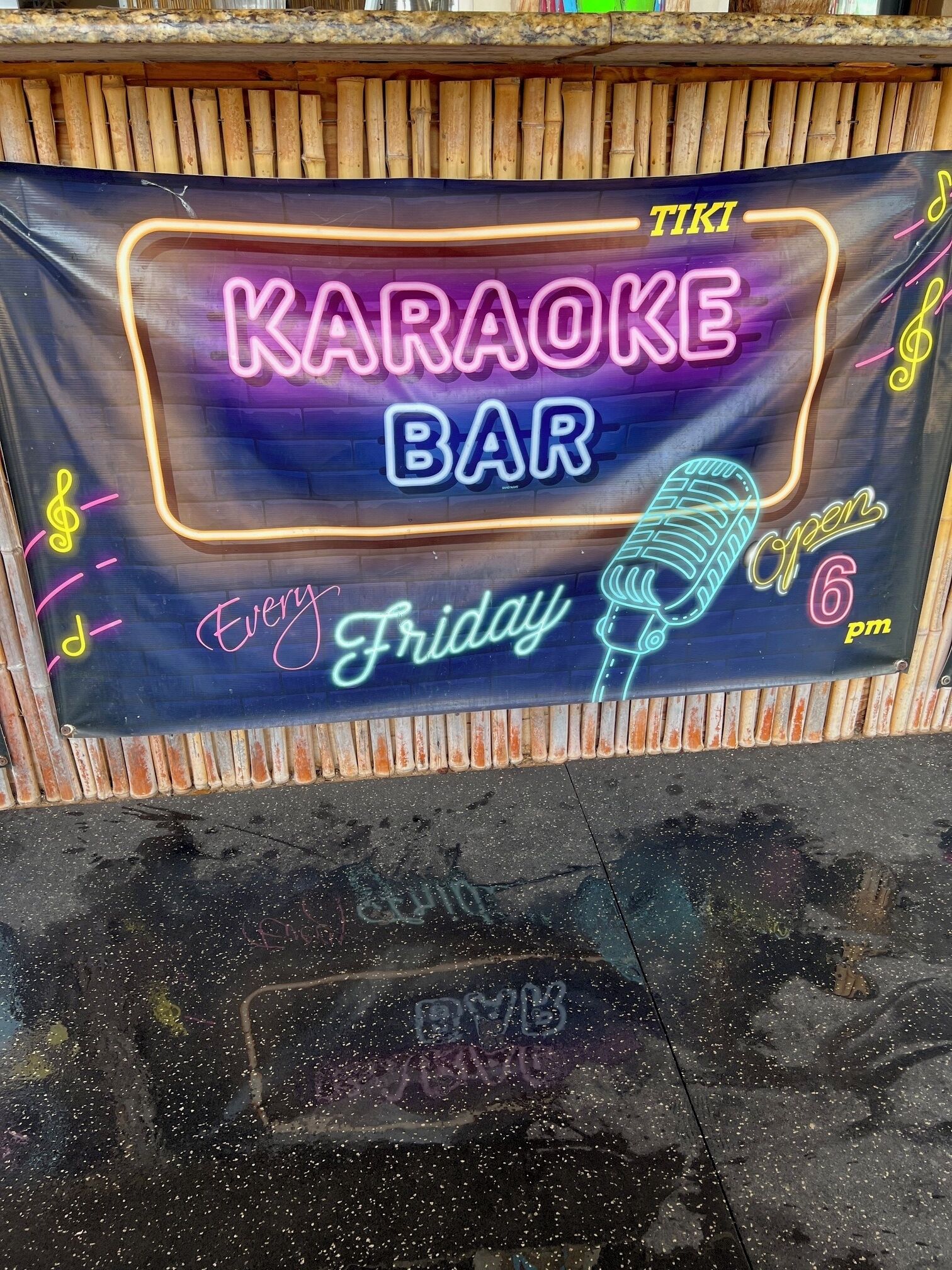 A neon sign advertising a karaoke bar that is open every Friday from 6 pm.