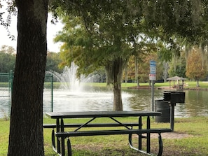 Enjoy a serene picnic in a tranquil park setting with a fountain and a gazebo nearby.