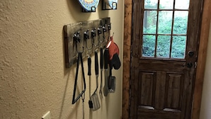 Una puerta de madera con un ventanal, un soporte de utensilios en la pared y dos platos decorativos.