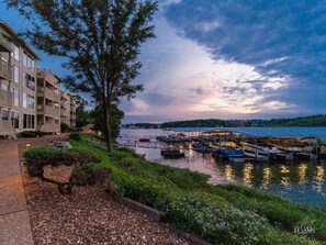 Waterfront property with balconies overlooking a marina and lush garden.