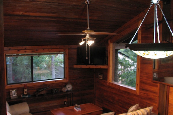 The living room has a high ceiling and lots of natural light.