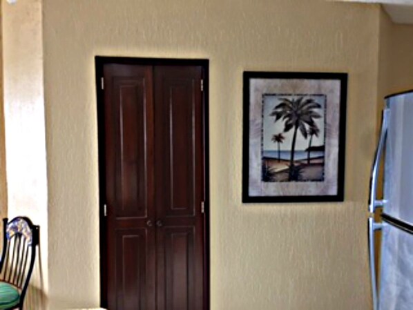 Una puerta y un cuadro con una imagen de una playa en la pared.