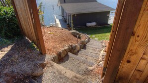 Um deck de madeira leva a uma casa com vista para um lago.