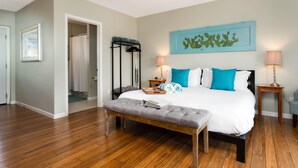 A bedroom with a large bed, a bench, a ceiling fan, and a cactus artwork on the wall. - PRIVATE HEATED SWIMMING POOL & HOT TUB Amazing Views, Privacy & Close to SEDONA! (Cottonwood)